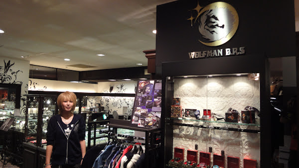 a young woman stands at the wolfman brs boutique that features a large logo and jewellery display cases